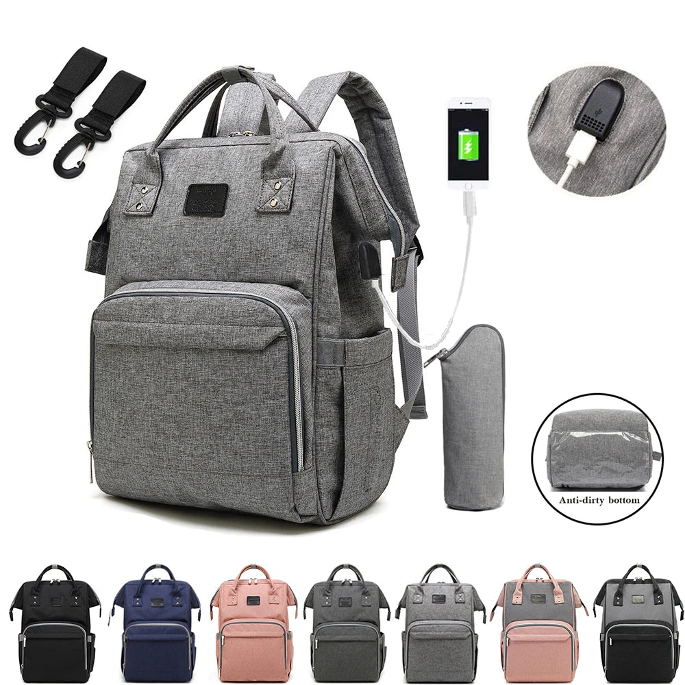 A Selluve Mochila de fraldas é uma mochila cinza compacta, porém espaçosa, com compartimentos inteligentes, porta de carregamento USB, porta-garrafa e dois ganchos para carrinhos de bebê. Seu fundo anti-sujeira garante durabilidade. Disponível em preto, azul e rosa.