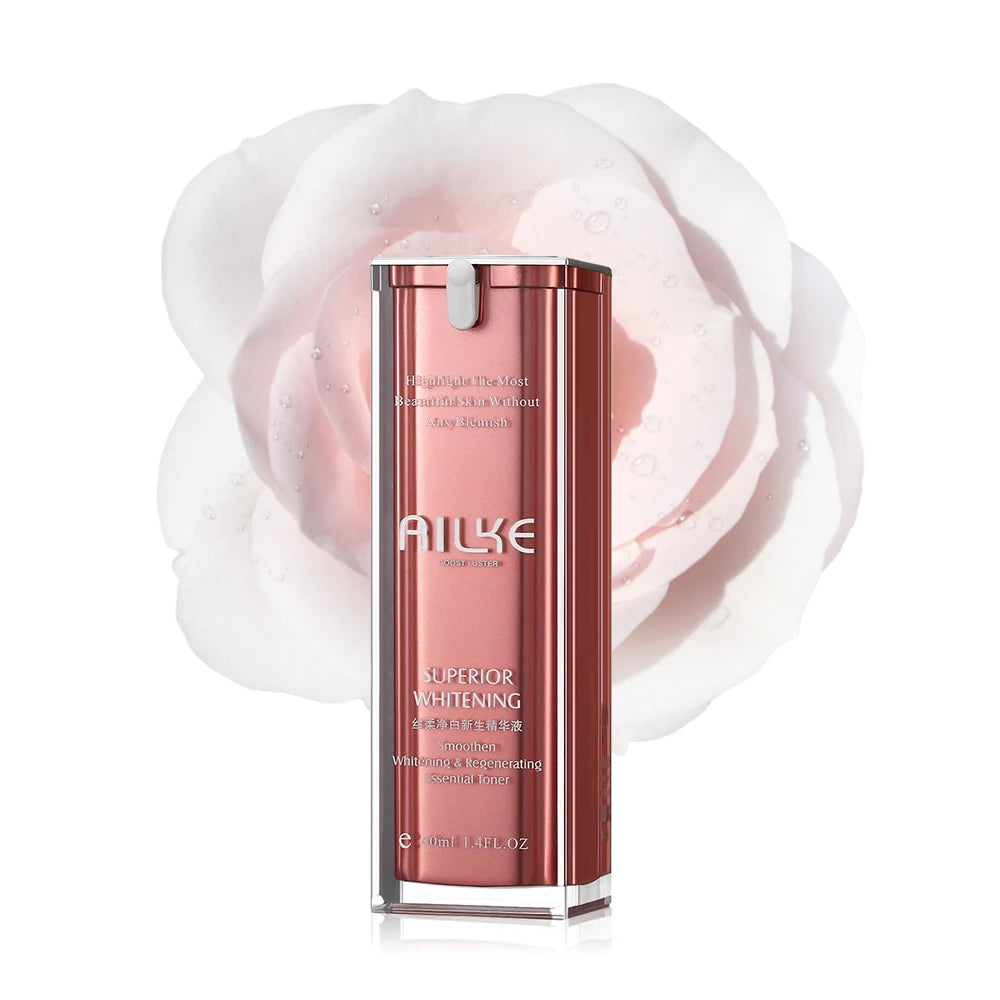 Um frasco rosa elegante do tratamento facial Soro de antienvelhecimento da Selluve, conhecido por seus benefícios antienvelhecimento e clareadores, brilha com um acabamento metálico ao lado de uma grande rosa branca, oferecendo um clareamento de manchas eficaz para uma pele radiante.