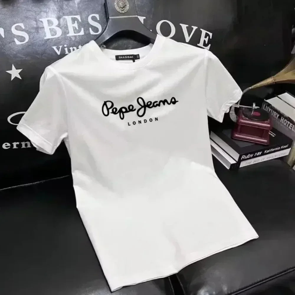 A camiseta branca Selluve Camisetas masculinas Pepe, conhecida por seu conforto premium, é elegantemente exibida em uma superfície preta cercada por outras peças de vestuário estilosas.