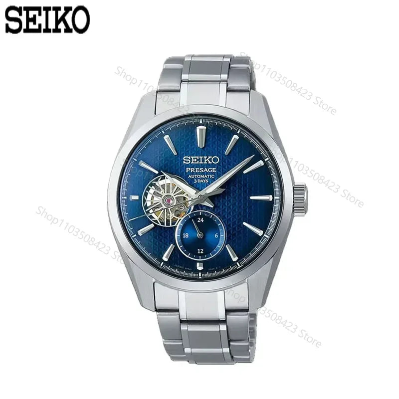 O relógio Selluve Japanese Seiko Machinery Automatic para homens apresenta um mostrador azul texturizado, componentes visíveis e um pequeno subdial. Aprimorado por sua pulseira prateada e movimento japonês preciso, ele combina elegância e funcionalidade. O icônico logotipo da Seiko adorna o canto superior esquerdo. Modelo SARJ003.